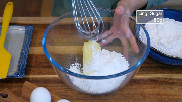 Image of Add the room-temperature unsalted butter and icing sugar into a big mixing bowl. Whisk them until fluffy. You could use granulated sugar, but it will take some time to whisk until dissolved.