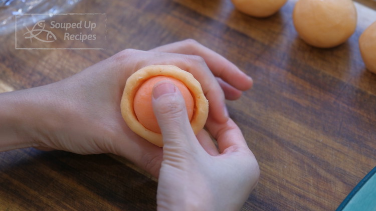 Image of Grab a wrapper dough, poke a hole in the middle, and shape it into a small little bowl. Put a filling in and use your forefinger and your thumb to squeeze around and push the wrapper up. When you get...