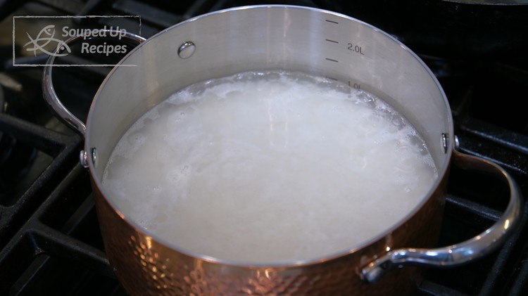 Image of Meanwhile, wash the rice under running water several times and drain thoroughly. Add 2 cups of water and 3 cups of water to a pot and bring it to a simmer over medium heat. Put on the lid and turn...