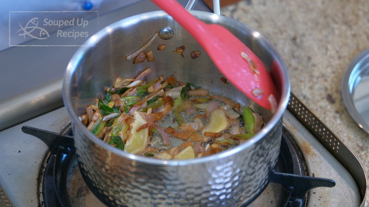 Image of Add cooking oil to a saucepan, along with the ginger slices, scallions, and shallots. Stir over medium-low heat for a few minutes or until the aromatics are golden.