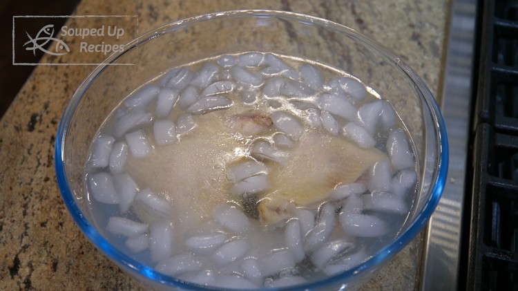 Image of Check the chicken by poking the thickest part with a fork. If there is not pink juice leaking out, the chicken is completely cooked through. Transfer the chicken into an ice bath to stop the cooking process.