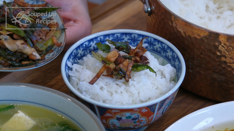 Image of By now, the rice should be done. Turn off the heat and fluff the grains. Garnish the rice with the reserved crispy aromatics.