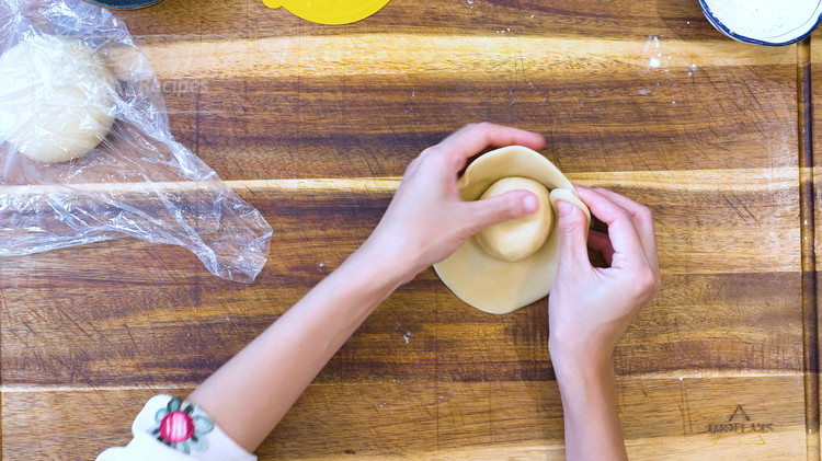 Image of Do the same thing to the other half of the dough. Roll the Shuiyoupi dough into a wrapper and use it to wrap the Yousu dough. Cover it with a plastic film and set it aside for 15 minutes.