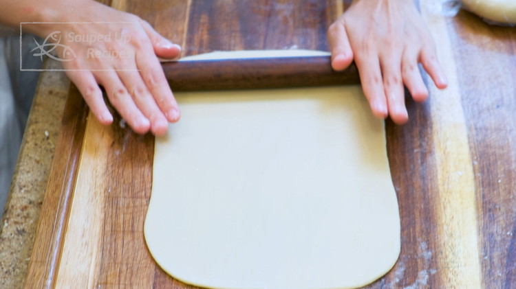 Image of By now, the first half should be done resting. Sprinkle some flour to prevent sticking. Roll it into a rectangle. It is very easy. You just push out 4 corners and it will turn into a rectangle. Fold the rectangle...