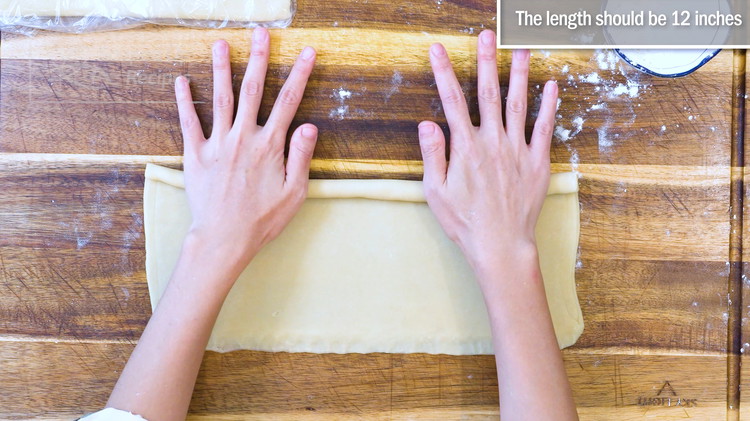 Image of Move back to the previous folded rectangle. It should be done resting. Continue to roll it into a bigger rectangle sheet. The size should be 12*6 inches. Lightly wet your hands and dab a little bit moisture on the surface....