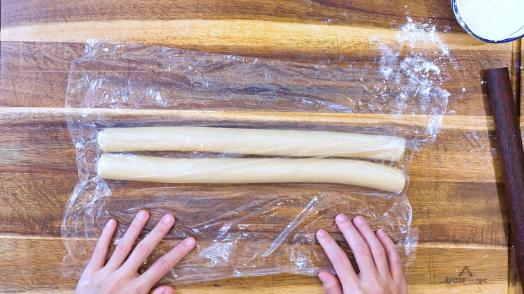 Image of Do the same thing and roll the other dough into a log. Make sure the length matches. Cover well and set it aside for 15 minutes.