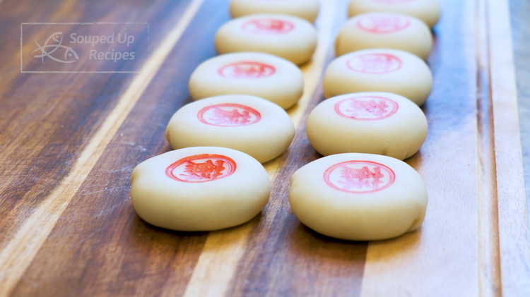 Image of Dilute some red food coloring in a little bowl with a tiny bit of water. Then place in a small paper towel. Dip the stamp in the food coloring and stamp the pattern on the mooncake. Make sure you do...