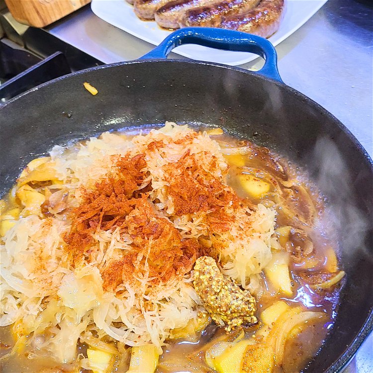 Image of Add the drained sauerkraut to the skillet with the onion,...