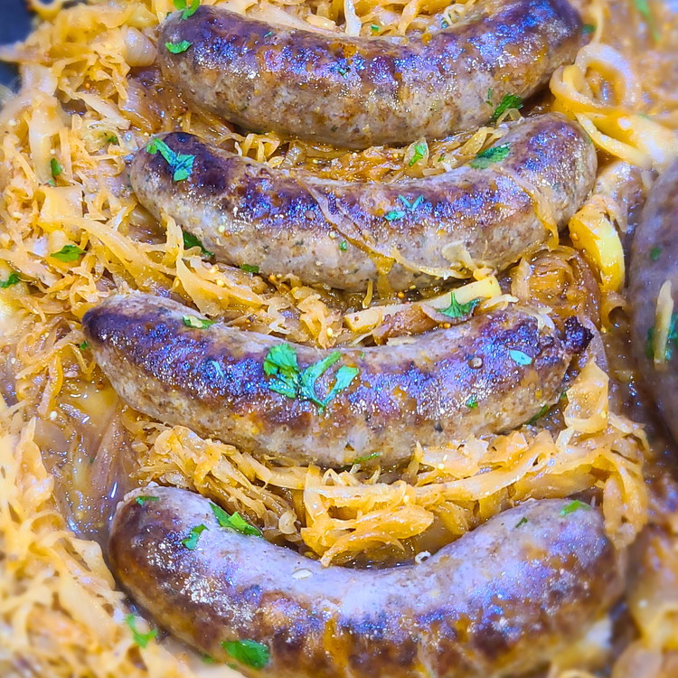 Image of Nestle the seared bratwurst into the sauerkraut mixture. Don’t forget to pur in any of the juices that may have gathered on the plate as well. Bring the liquid to a simmer.