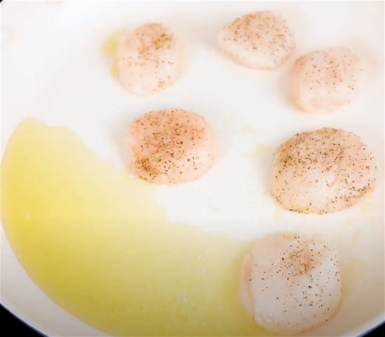 Image of Carefully place the seasoned scallops into the skillet, salted side...