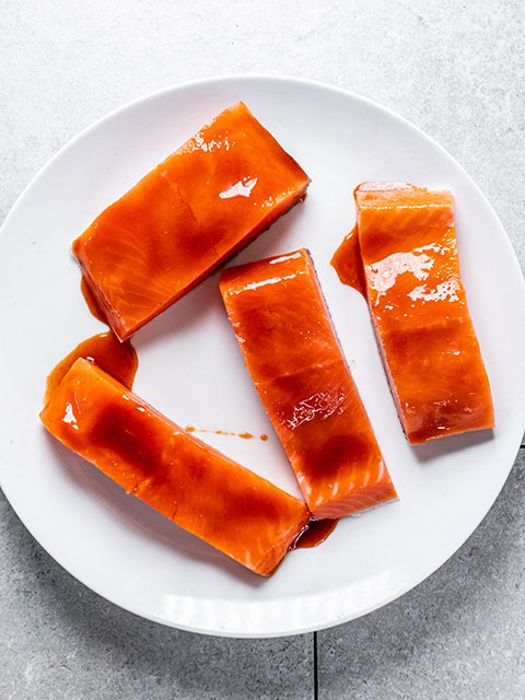 Image of Brush honey sriracha sauce on salmon. 