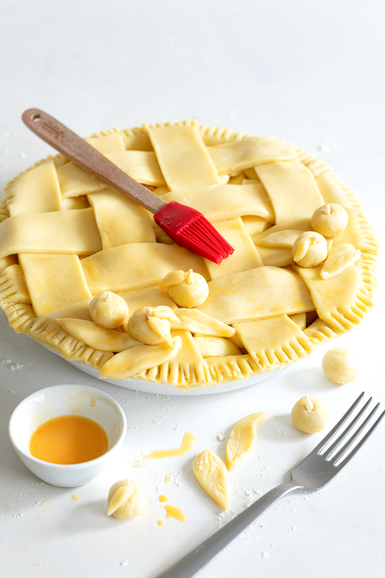 Image of Backofen auf 180 Grad Ober-/Unterhitze vorheizen. Das Eigelb mit der Milch verquirlen und mit dem Pinsel auf das Gitter streichen. Äpfel und Blätter dekorieren, mit Ei-Streiche festkleben, und ebenfalls mit Ei bestreichen. In den vorgeheizten Ofen stellen und 30 Minuten...