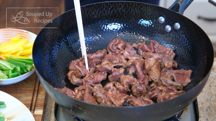 Image of Turn the heat to high and heat the wok until smoking hot. Add cooking oil and swirl it around so it covers the bottom. Add the beef. Spread it out. Let it cook over high heat for 2 minutes or...