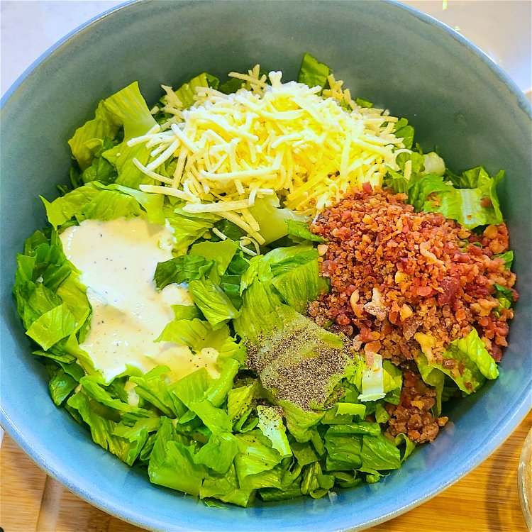 Image of In a large bowl, combine the chopped romaine lettuce, parmesan,...