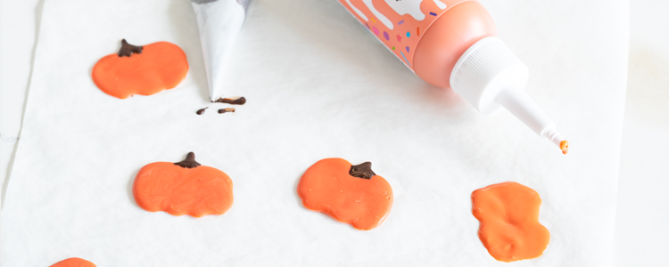 Image of Für die selbstgemachte Dekoration mit dem orangenenSuperDrip und Schokolade kleine Kürbisse auf Backpapier spritzen. So lassen sie sich nach dem Trocknen gut lösen. Für perfekt geformte Kürbisse kannst du mit einem Zahnstocher hier und da die Form korrigieren.