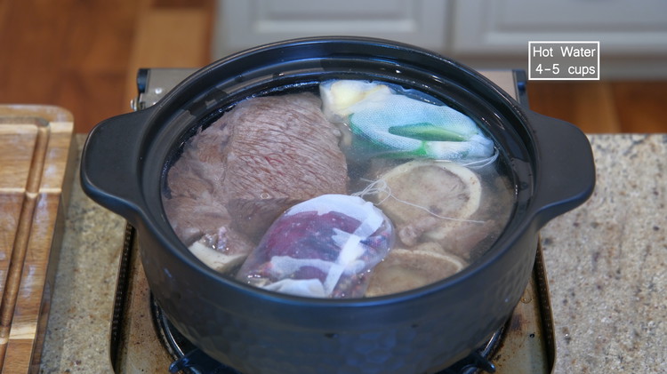 Image of Transfer the beef and the bones into a new, clean clay pot. Fill the clay pot with 4-5 cups of hot water or enough to immerse all the ingredients. Add the spice bags. Simmer the beef over low heat for...