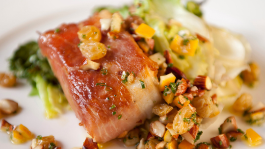 Image of  Prosciutto-Wrapped Halibut over Couscous with shaved Brussels Sprouts