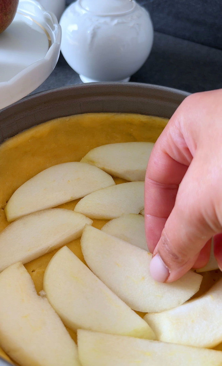 Image of Coloca las rodajas de pera uniformemente sobre la masa en el molde para hornear.