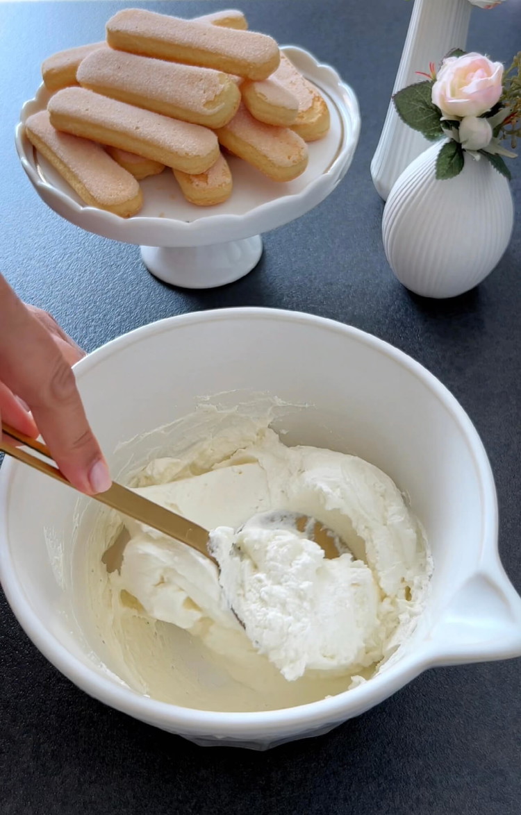 Image of In einer Schüssel Mascarpone, Zucker, Vanilleextrakt und Sahne mit einem Handmixer vermengen, bis eine glatte, cremige Mischung entsteht.