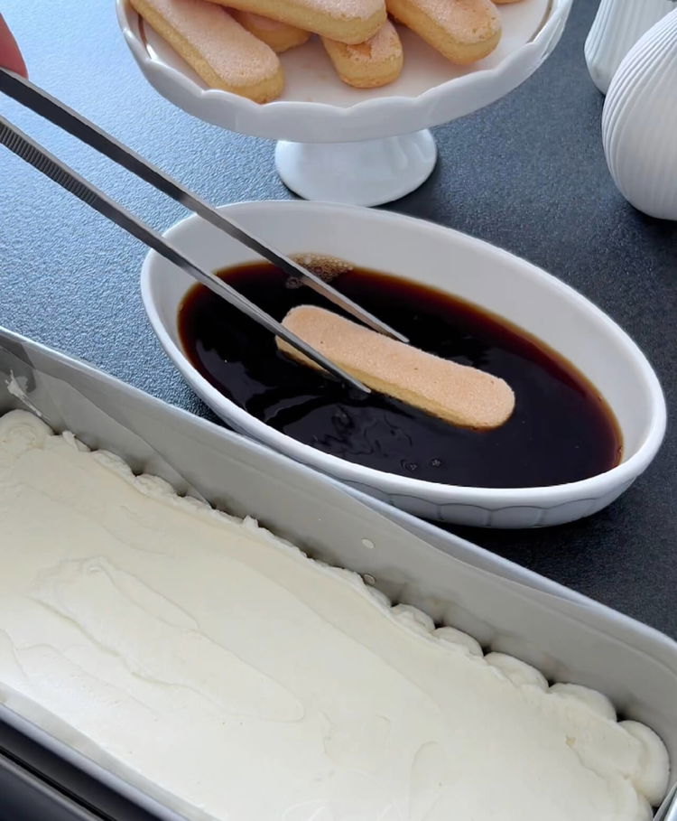 Image of Coloque uma camada de biscoitos ladyfinger brevemente embebidos sobre o...