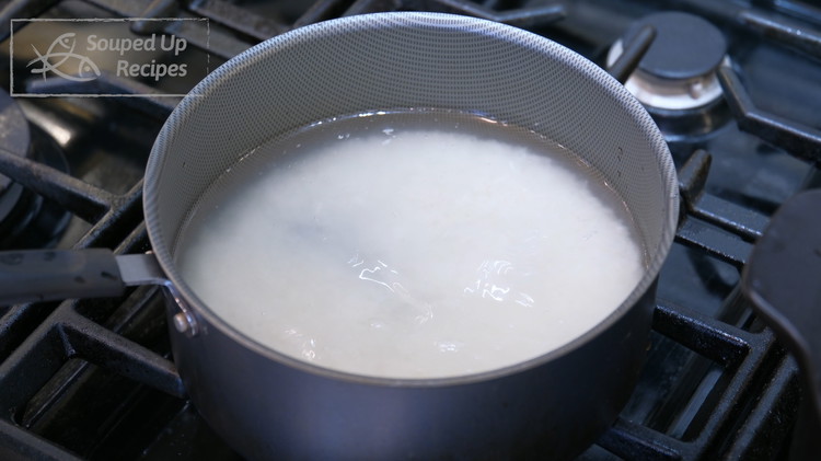 Image of Add rice and water to a pot and turn the heat to medium. It will take about 5 minutes for it to come to a boil.