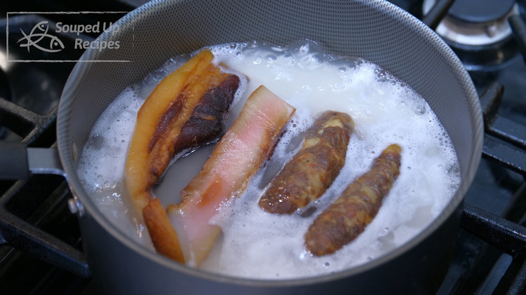 Image of Add a couple pieces of Chinese cured pork belly (remove the skin because it is chewy) and sausage and put on the lid. Switch the heat to low and let it simmer for 18 minutes.