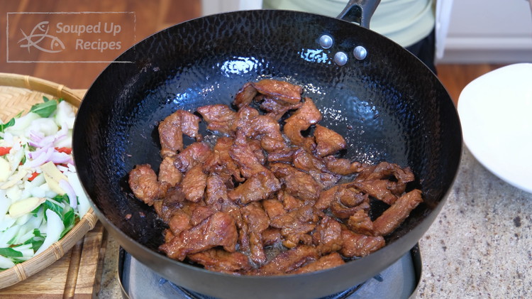Image of Turn the heat to high and heat the wok until smoking hot. Add some cooking oil and swirl it around so it covers the bottom. Add the beef. Spread it out. Let it cook until the meat changes color. The...