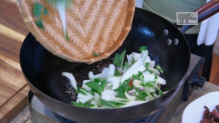 Image of To the same wok, we will toss in the bok choy stem along with the garlic, ginger, shallots slices, and thai bird eye chilies. Reserve the leaves for making the soup.