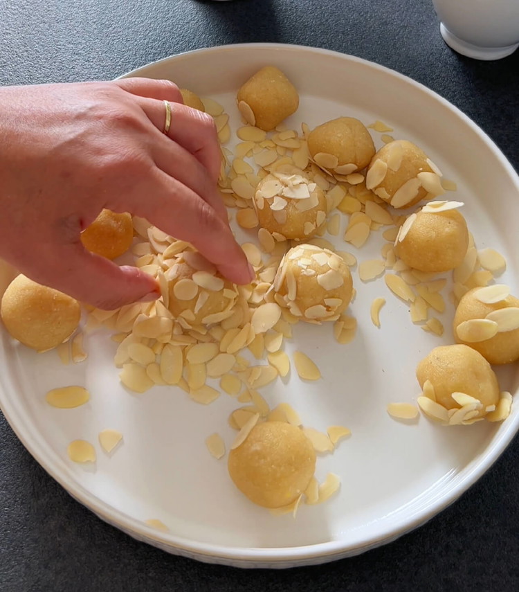 Image of Coloque as bolinhas cobertas de amêndoa na assadeira preparada.