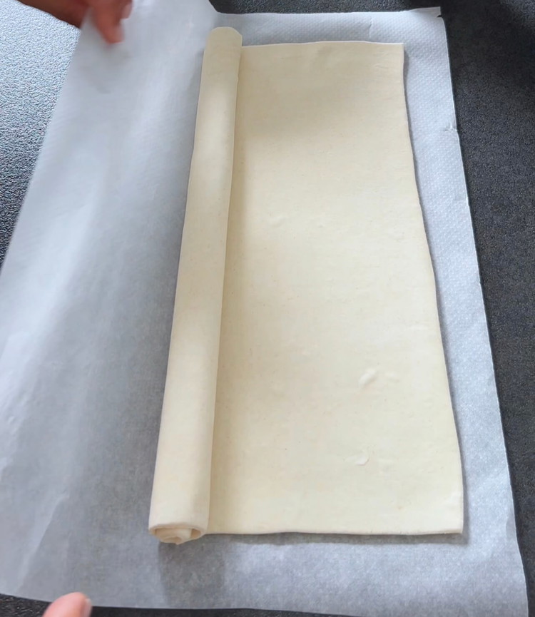 Image of Rollen Sie den Blätterteig aus und schneiden Sie ihn in 12 gleichmäßige Stücke mit etwa 3 cm Abstand. Bereiten Sie eine Muffinform mit 12 Vertiefungen vor (oder verwenden Sie originale Tarteformen).