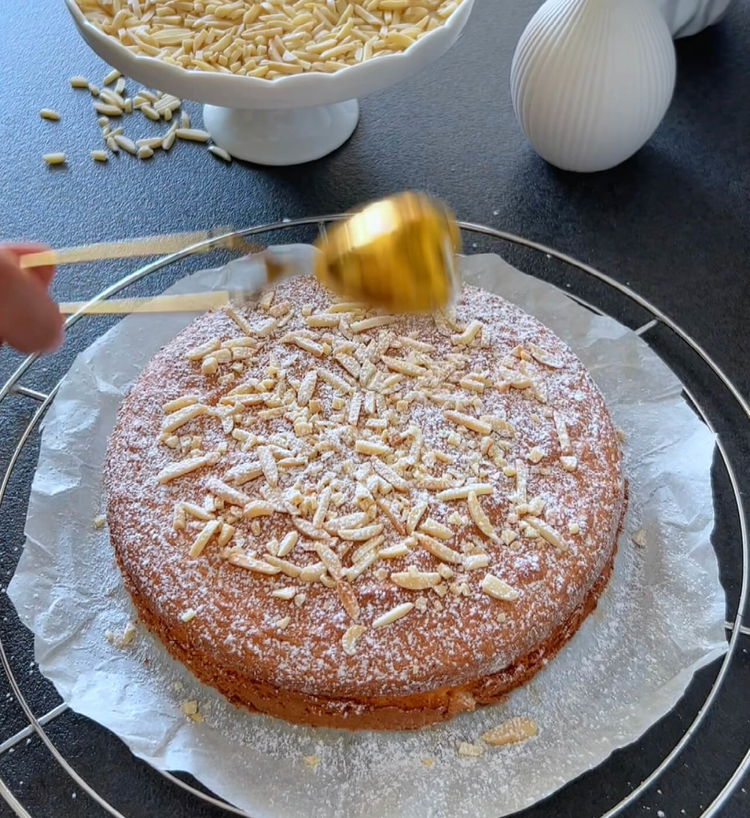 Image of Decora la torta raffreddata con scaglie di mandorle sbollentate e...