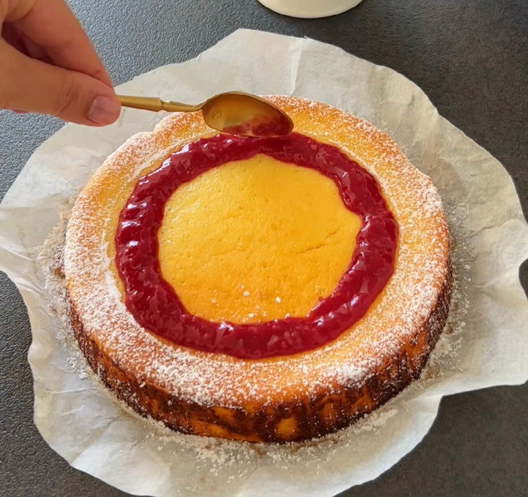 Image of Soğuyan cheesecake'in üzerine ahududu sosunu dökün.