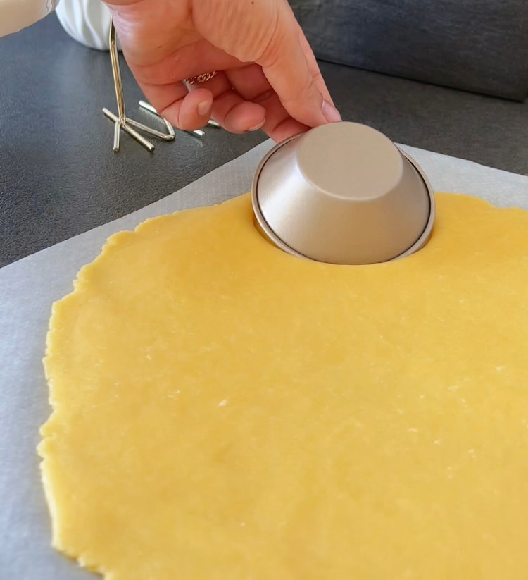 Image of Stendi l'impasto, taglia dei cerchi per gli stampi delle tartelettes e premi delicatamente. Rimuovi l'impasto in eccesso.