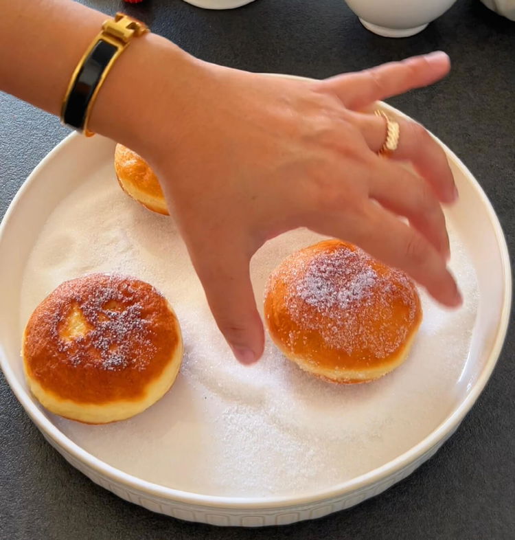 Image of Valjajte Berlinere u šećeru dok ne budu lagano prekriveni.