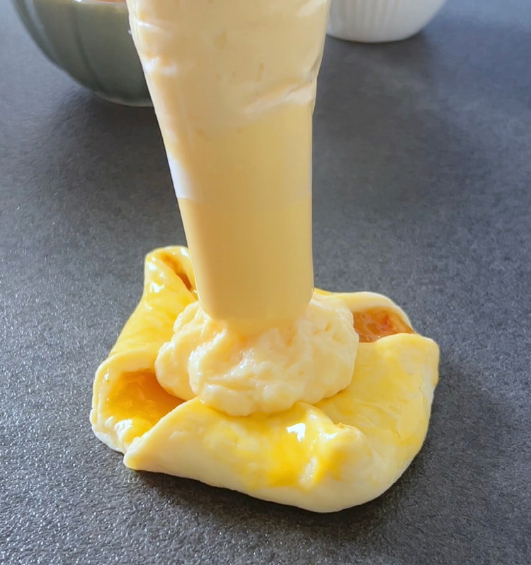 Image of Legen Sie etwa 1-2 Esslöffel Pudding in die Mitte jeder Tasche.