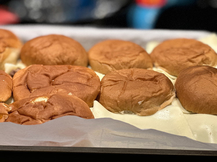 Image of Top your meat with a slice or two of cheese per bun and cover with the top buns.