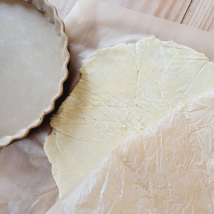 Image of Nach der Teigruhe den Teig zwischen zwei Backpapieren auf die Blechgrösse auswallen