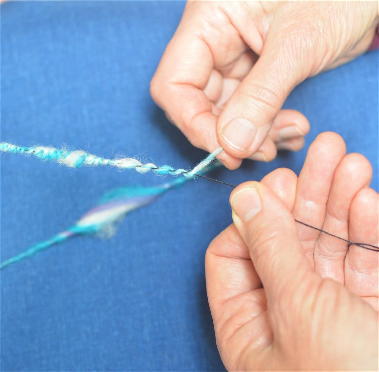 Image of Tie both yarns to the leader. This time, spin in...