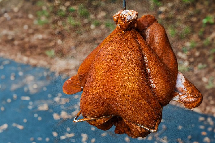 Image of Position the turkey on the frying rack and tie the...