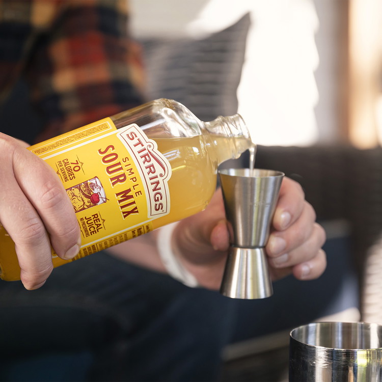 Image of Measure and add 2 ounces of Stirrings Sour Mix to the shaker.