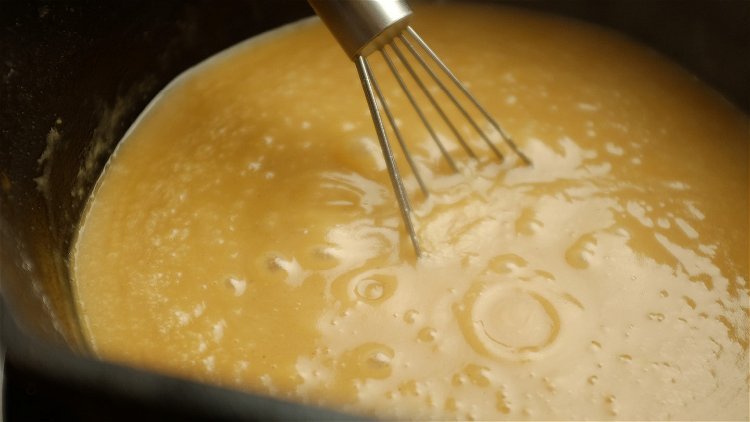 Image of Slowly pour the turkey drippings and turkey stock into the...