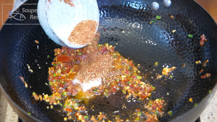 Image of Continue by adding five-spice powder, sugar, 2/3 of the Sichuan peppercorn, and chili powder. Reserve 1/3 to sprinkle at the end.