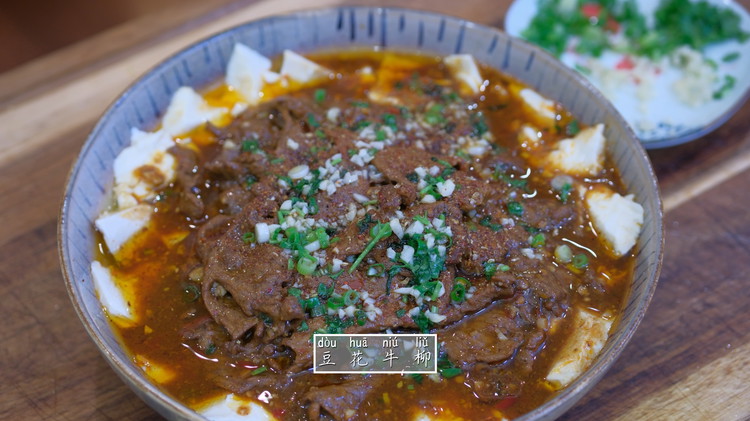 Image of Pour the beef onto the tofu and sprinkle the reserved Sichuan peppercorn chili powder, minced garlic, diced scallions, and cilantro. Heat 2-3 tbsp of oil to smoking hot and pour it on top of the aromatics to activate all the...