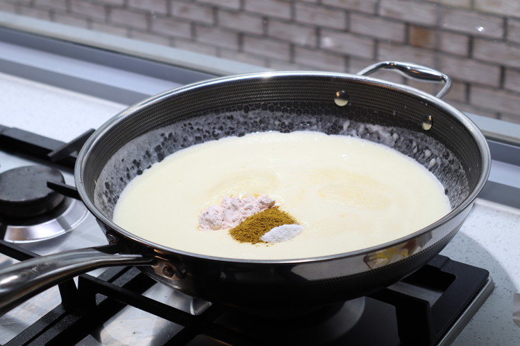 Image of add custard powder, curry, and cracked black pepper