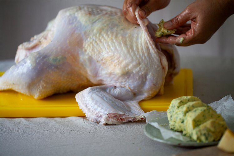 Image of Place 1/4 of the remaining butter inside the turkey and...