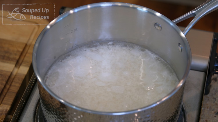 Image of Add the rice and water into a pot and bring it to a simmer over high heat. This will take just a few minutes. Don't go away because it will overflow if you forget the time.