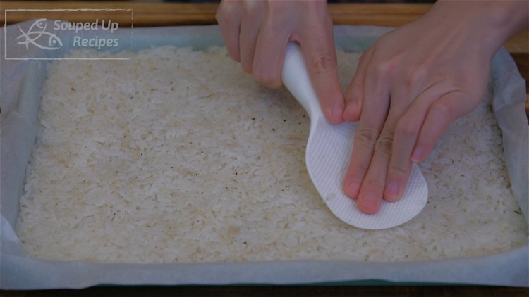 Image of Even spread the rice in the baking pan and press...