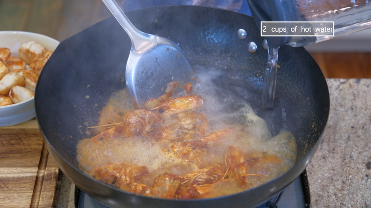 Image of Switch the heat to high and pour in 2 cups of hot water. Put on the lid and let it simmer over low heat for a couple of minutes.