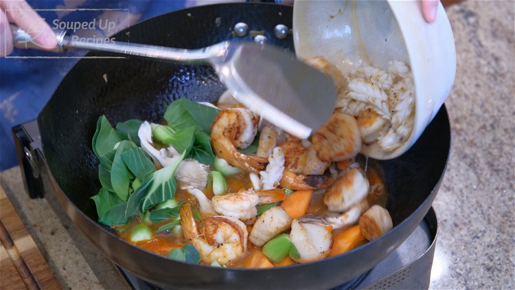 Image of Toss in the carrot, mushrooms, bok choy, and seafood.