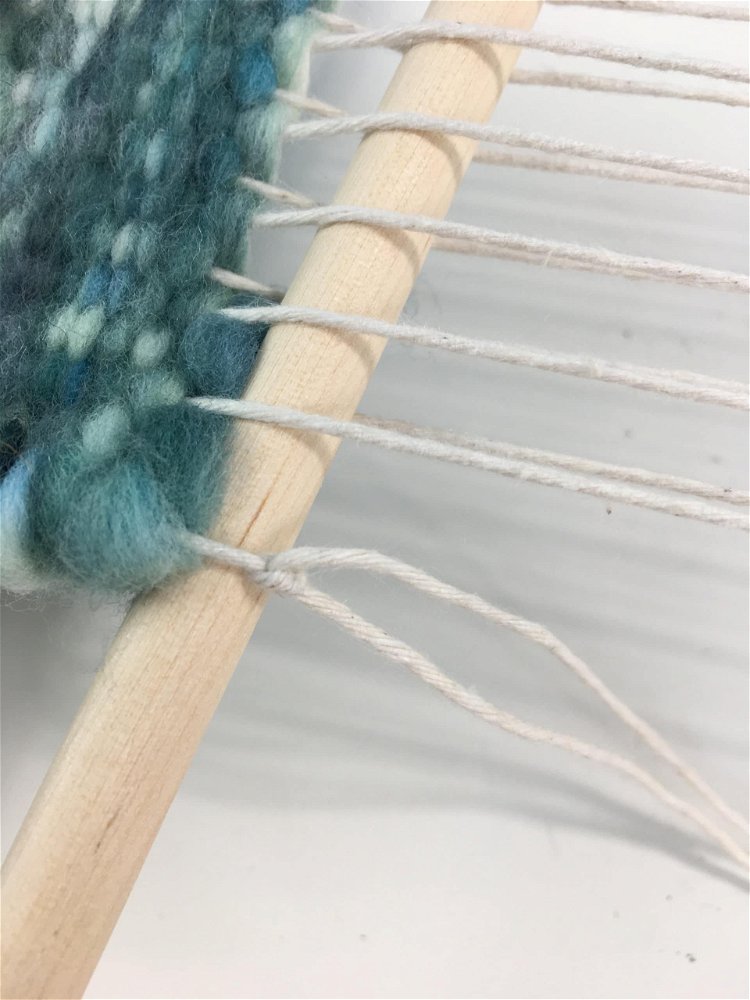 Image of Start snipping and tying the warp threads to the dowel.